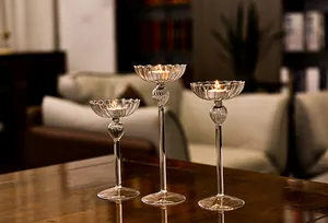 Atmospheric shot of three elegant ribbed glass candle holders on a dark wooden table