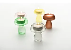 Portacandele in vetro colorato a forma di fungo con candele tealight accese per casa.