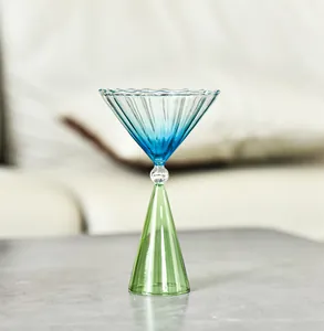 Nahaufnahme eines kreativen gestreiften Glases mit blau-grünem Farbverlauf für Desserts