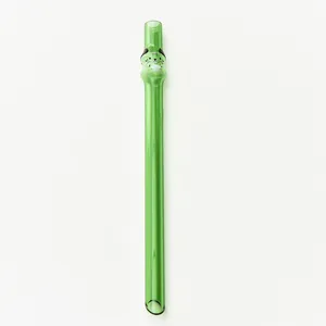 Macro detail of green glass straw featuring a cute cat character and pointed tip.