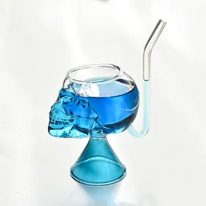 Primer plano de un vaso de vampiro con forma de calavera, líquido azul y pajita.