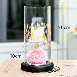 Detail view of the 20cm tall glass candle holder featuring a pink decorative flower inside