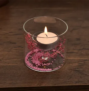 Detailweergave van cilindrische glazen kaarsenhouder met roze bloemen