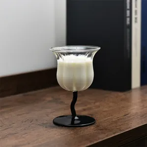 Vista detallada de una copa con forma de lirio de los valles y elegante tallo negro curvo