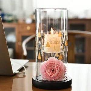 Elegant European style cylindrical glass candle holder with lit candle and pink rose decor