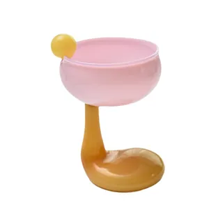Elegante copa de postre rosa y amarilla con un tallo curvado de diseño artístico