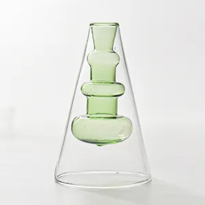 Detail view of a creative Nordic double-layer green glass vase for desktop decoration