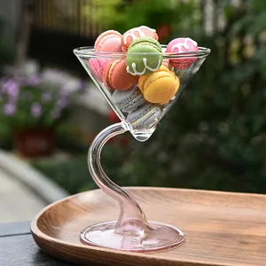 Close-up of creative S-shaped stem glass dessert bowl filled with colorful macarons outdoors