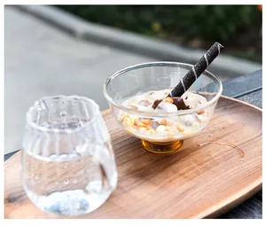 Bol à dessert artisanal en verre avec socle ambré sur un plateau en bois