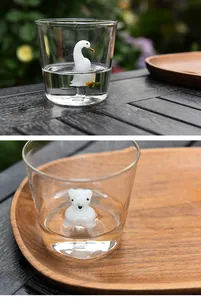 Detail view of 3D glass swan and polar bear figurines inside clear water cups