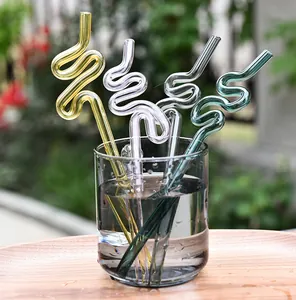 Pajitas de vidrio artísticas de colores creativas en un vaso de agua, ecológicas.