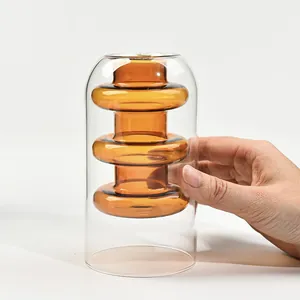 Close-up view of a creative amber double-layer glass vase with unique stacked inner ring design.