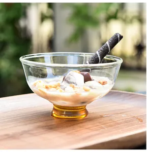 Détail exquis d'un bol à dessert en verre fait main avec une base de couleur ambre.