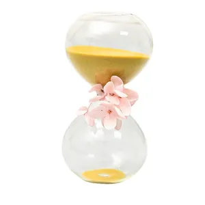 Nordic style glass hourglass timer with yellow sand and pink dried flower decoration