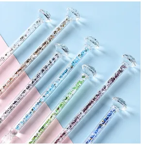 Macro view of glass dip pens featuring colorful internal crystals and diamond shaped tops.