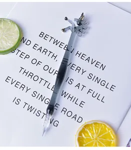 Macro view of a handmade black gradient unicorn glass dip pen on artistic letter background