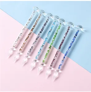 Close-up detail of seven colorful glass dip pens with diamond tops and crystal fill