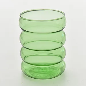 Dettaglio di un bicchiere in vetro verde a coste resistente al calore con design a onde