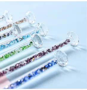 Macro detail of glass dip pens with colorful crystal beads and diamond-shaped tops