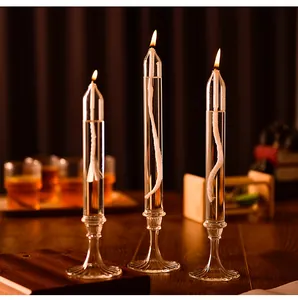 Vista detallada de tres elegantes lámparas de aceite de vidrio encendidas en una mesa