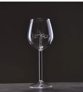 Detalle de una copa de vino creativa con una escultura de tiburón dentro.