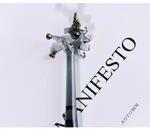 Detail shot of a handmade glass unicorn dip pen on a minimalist artistic background.