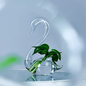 Elegant swan-shaped clear glass flower vase with green plant for minimalist home decor