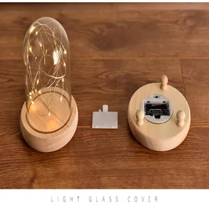 Detailed view of glass dome light with wooden LED base and battery compartment