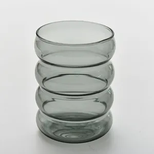 Vista dettagliata del bicchiere ondulato grigio fumo con un design unico a forma di bruco.