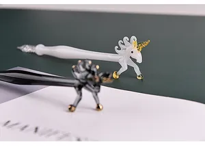 Close-up of handmade glass dip pens with elegant unicorn-shaped figurine details