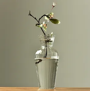 Elegant Japanese style fluted glass vase with a blooming branch for zen home decor.