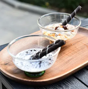 Vue détaillée de deux bols à dessert en verre créatifs avec des bâtonnets au chocolat sur bois