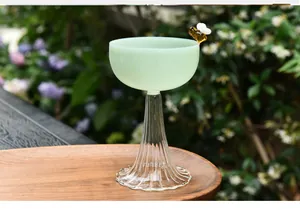 Elegant pale green glass dessert goblet featuring a decorative bee ornament on its rim