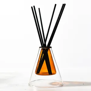 Modern double-walled glass reed diffuser bottle with amber inner core and black sticks