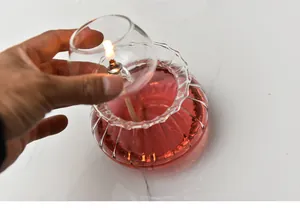 Detailed view of placing the glass wick holder into the red glass oil lamp base