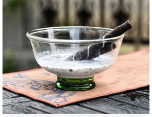 Gros plan d'un élégant bol à dessert en verre avec base verte et gaufrettes chocolat