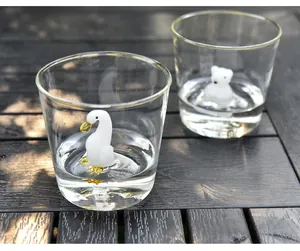 Detailed view of handmade 3D swan and bear figurines inside clear glass water cups