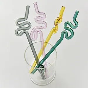 Pajitas de vidrio de colores con formas artísticas en un vaso para bebidas creativas