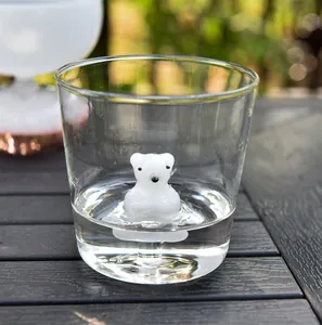 Close-up detail of a cute white polar bear figurine fixed inside a clear glass cup