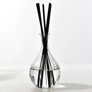 Close-up of a ribbed glass aromatherapy diffuser bottle with elegant black reed sticks