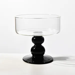 Elegant minimalist clear glass dessert bowl with unique black bulb pedestal base.
