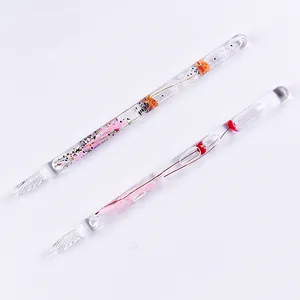 Macro view of elegant handmade glass dip pens featuring colorful dried flowers inside