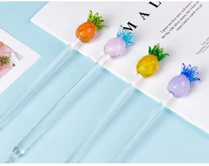 Detailed view of colorful pineapple-shaped toppers on elegant glass dip pens