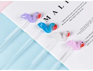 Close-up of glass dip pens with colorful flamingo decorations