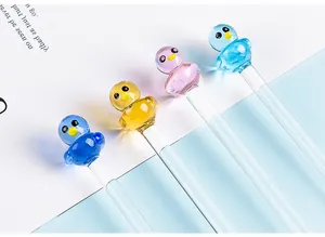 Close-up of colorful cartoon duck glass dip pens on a blue and white background.