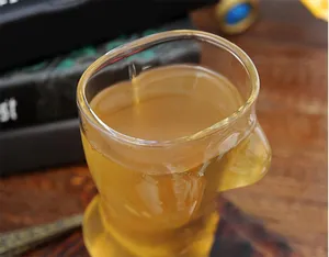 Nahaufnahme eines kreativen Glasbechers in Form eines weiblichen Körpers mit Tee