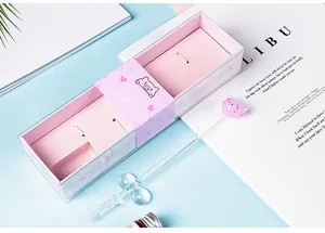 Close-up of pink pig glass dip pen set with a decorative gift box and pen rest.