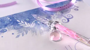 Close-up of elegant pink glass dip pen nib with spiral texture and dried flower