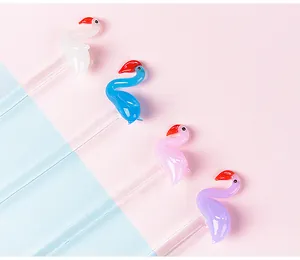 Detailed view of handmade glass dip pens with colorful flamingo toppers in pastel colors