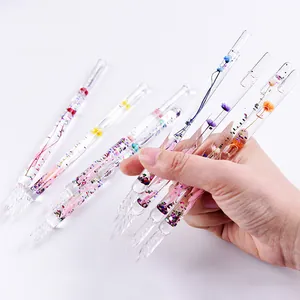 Detailed view of handmade glass dip pens with colorful dried flowers inside